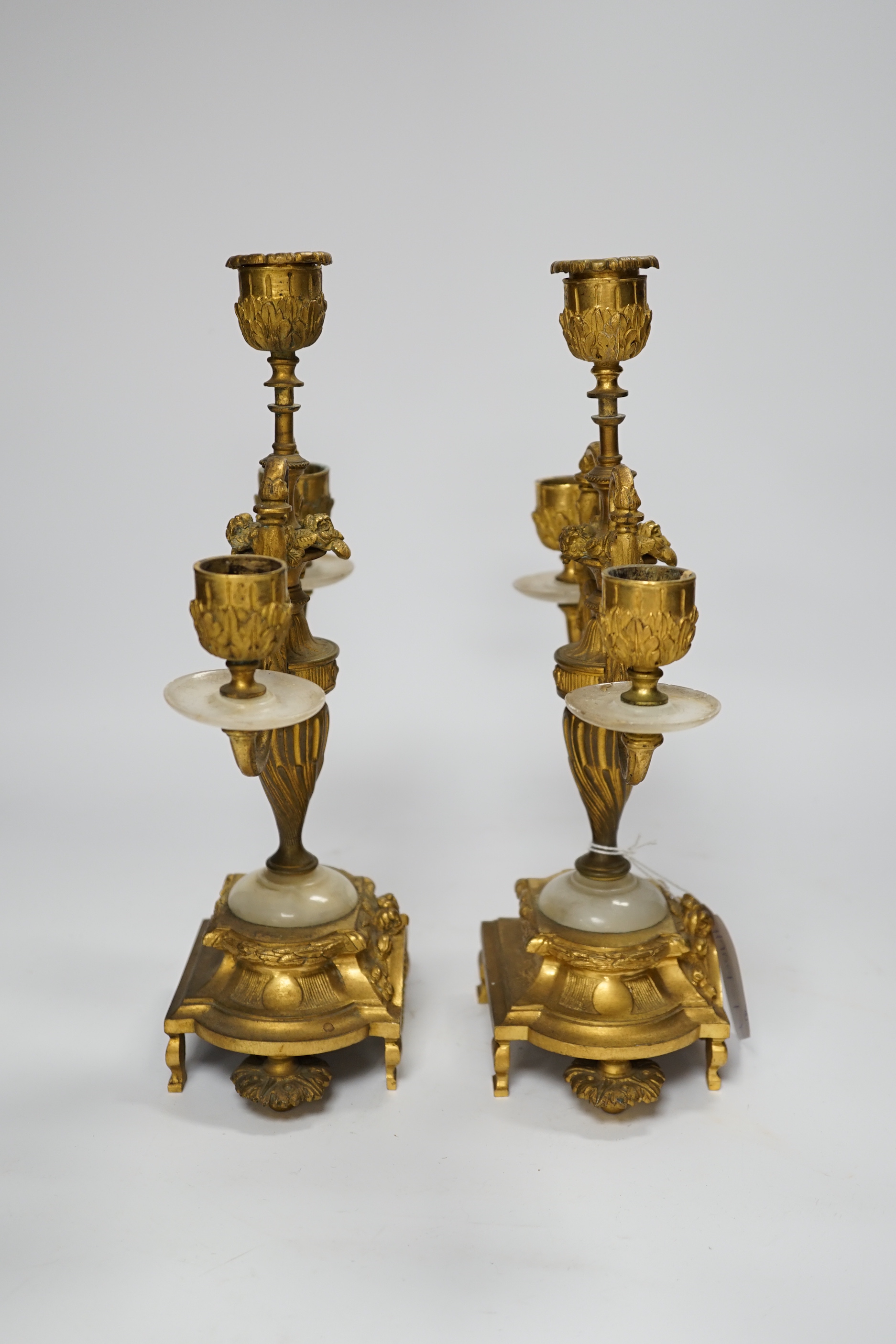 A pair of Louis XVI style ormolu and white onyx three branch candelabra, 29cm high